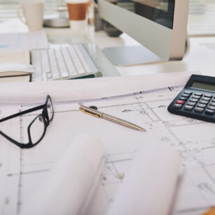 Construction plan and calculator on table on engineer